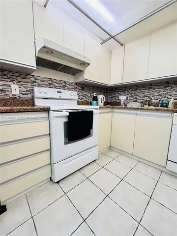 a kitchen with stainless steel appliances granite countertop a stove a sink and a white cabinets