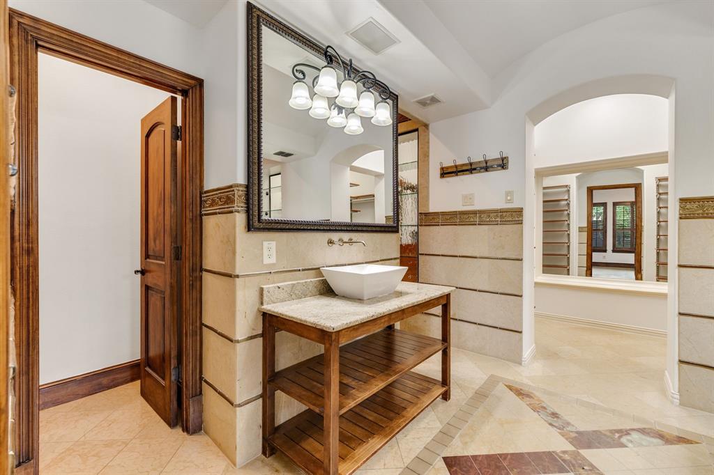 18231 Brighton Green Dallas, TX 75252 - Photo 22 of 36 a bathroom with a sink a mirror and a shower