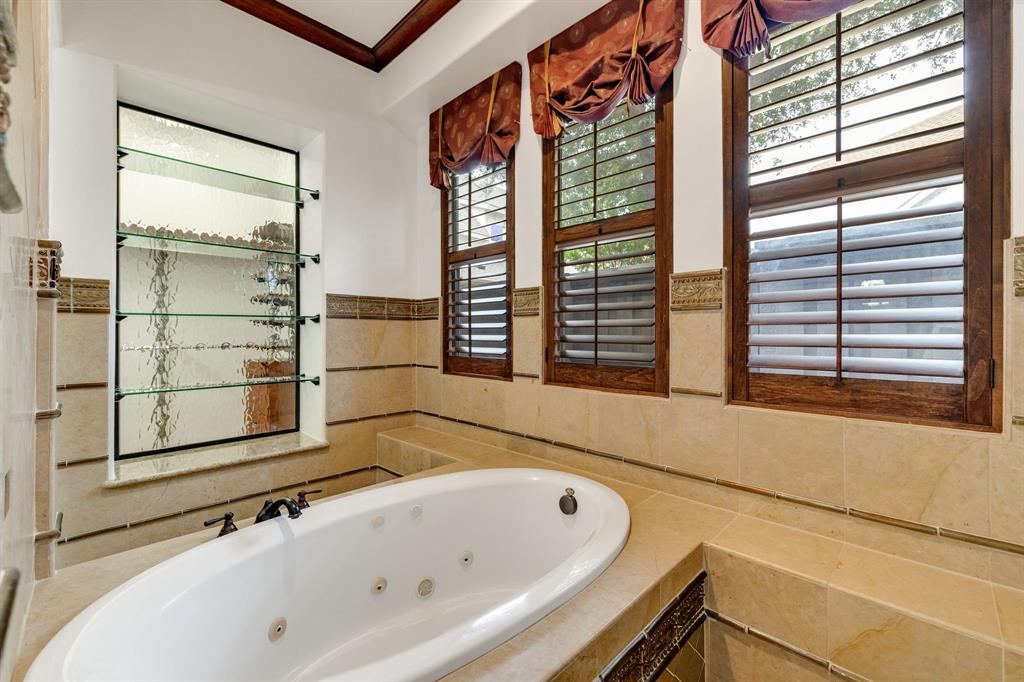 18231 Brighton Green Dallas, TX 75252 - Photo 23 of 36 a bathroom with a bathtub and a window