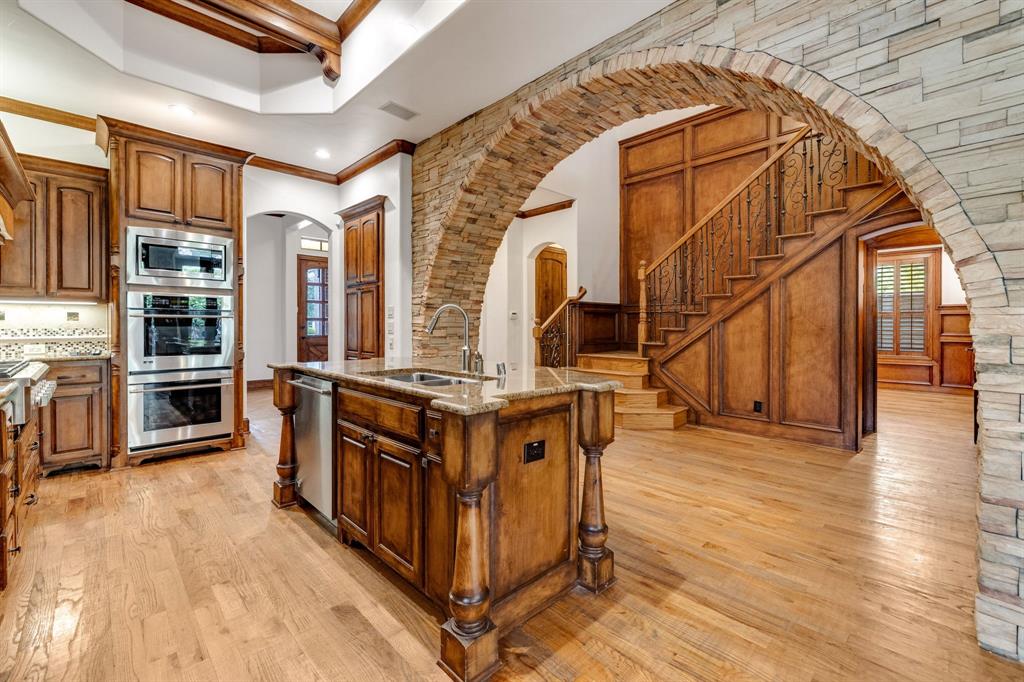 18231 Brighton Green Dallas, TX 75252 - Photo 10 of 36 a kitchen with stainless steel appliances a stove and wooden floor