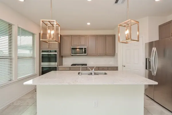 a kitchen with stainless steel appliances a refrigerator sink and microwave