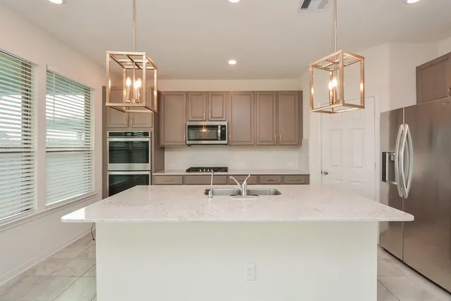 a kitchen with stainless steel appliances a refrigerator sink and microwave