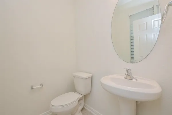 a bathroom with a toilet a sink and a mirror