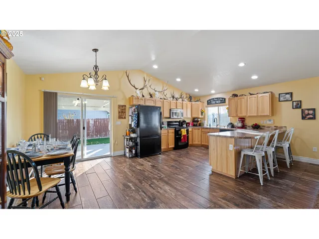 a living room with stainless steel appliances kitchen island granite countertop a dining table chairs and a oven