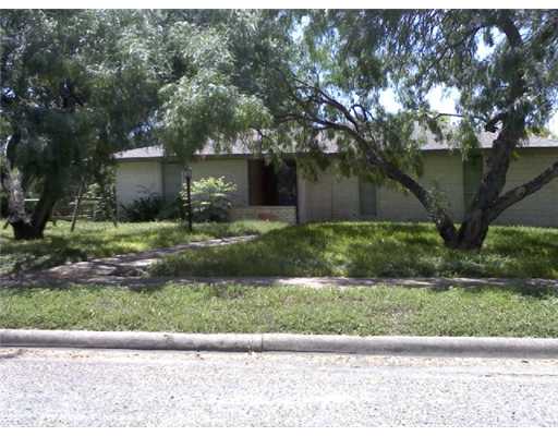 a view of a house with a yard and large tree