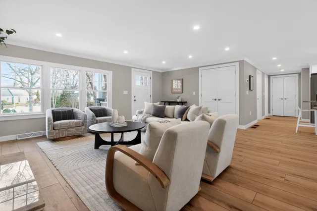 a kitchen with stainless steel appliances granite countertop a stove top oven a sink a refrigerator with white cabinets and wooden floor