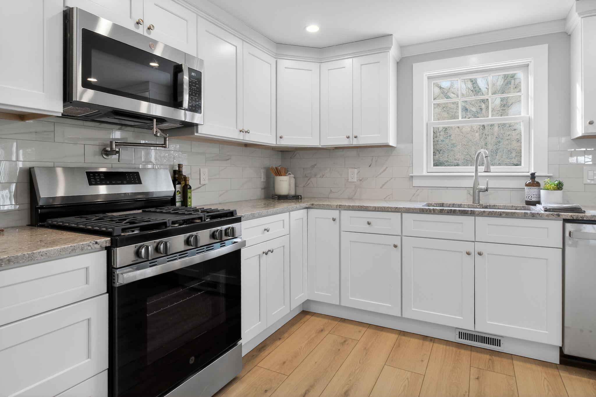 53 Eel River Road East Falmouth, MA 02536 - Photo 22 of 42 a kitchen with stainless steel appliances white cabinets granite counter tops and a window