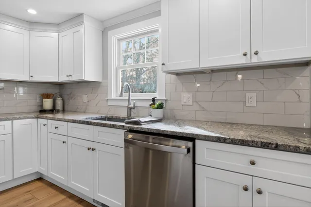 a bathroom with a granite countertop sink a toilet and bathtub