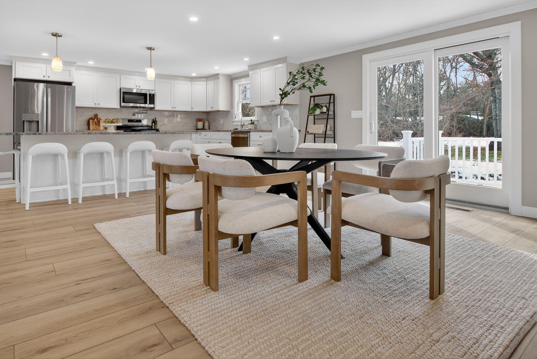 53 Eel River Road East Falmouth, MA 02536 - Photo 31 of 42 a kitchen with stainless steel appliances wooden floor dining table and chairs