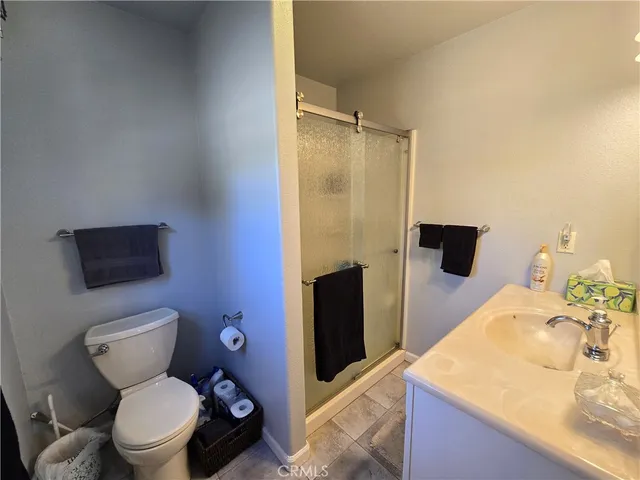 a bathroom with a granite countertop toilet sink and mirror