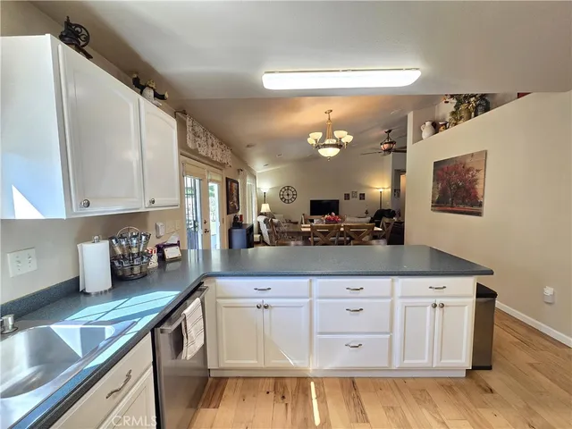a kitchen with white cabinets and chandelier