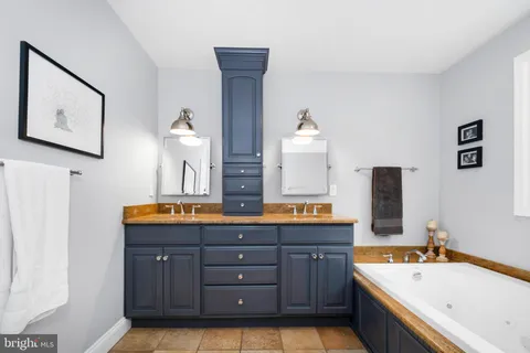 a bathroom with a tub a sink and a window