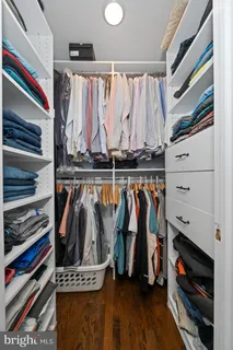 a view of walk in closet with clothes and shoes