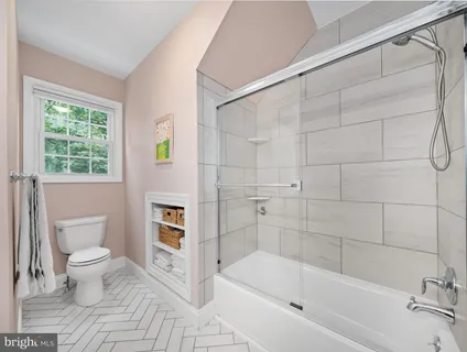 a bathroom with a granite countertop sink toilet and mirror