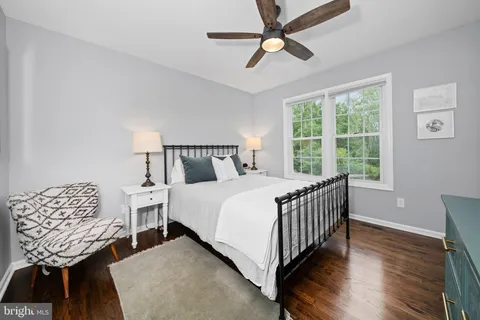 a bedroom with a large bed and wooden floor
