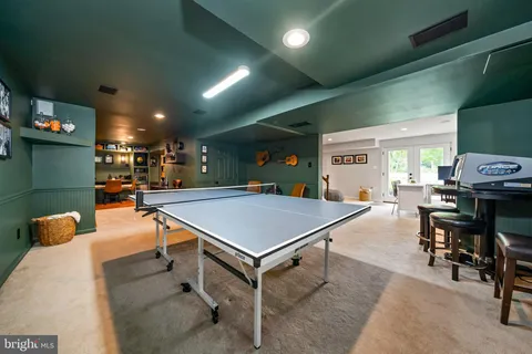 a room with furniture pool table and window