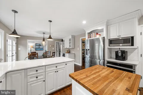 a kitchen with a table chairs refrigerator and cabinets