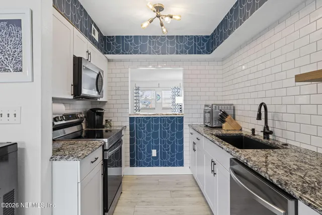 a kitchen with stainless steel appliances granite countertop a stove and a microwave