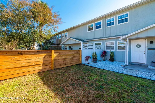 a view of a backyard with wooden fence
