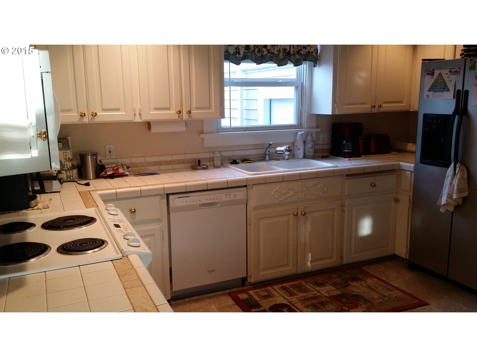 16711 Southeast McKinley Road Portland, OR 97236 - Photo 12 of 20 a kitchen with a sink a stove cabinets and a window