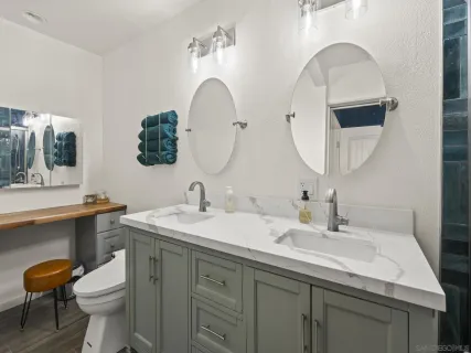 a bathroom with a double vanity sink mirror and toilet