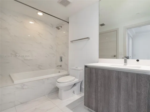 a bathroom with a sink toilet a mirror and a bathtub