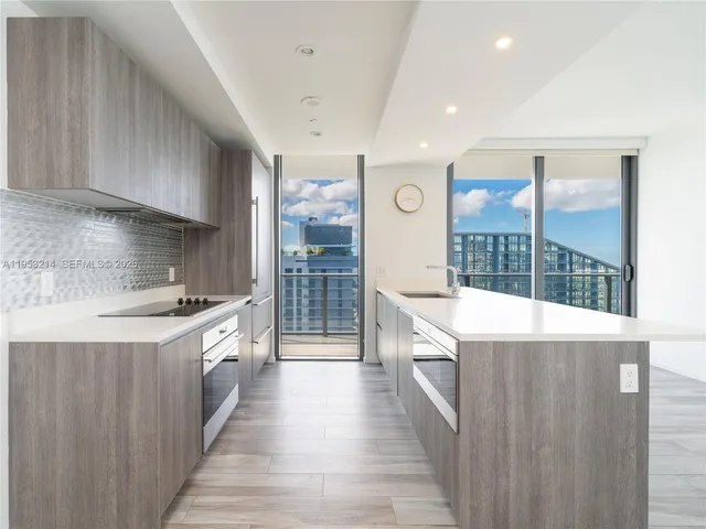 a large kitchen with a large window and stainless steel appliances