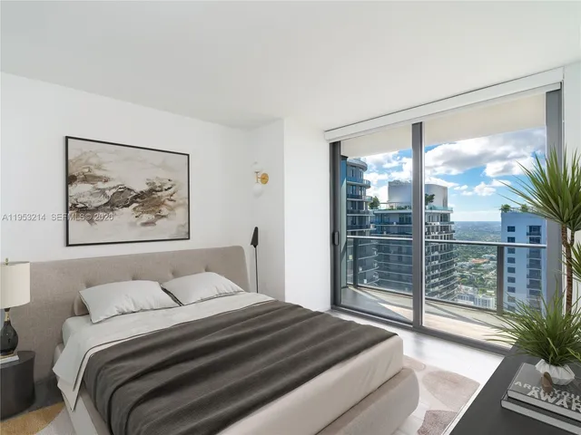 a bedroom with a large bed and a large window