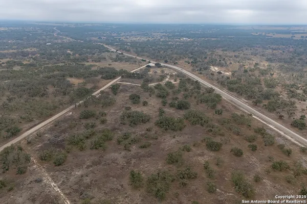 a view of a dry yard with wooden floor and fence