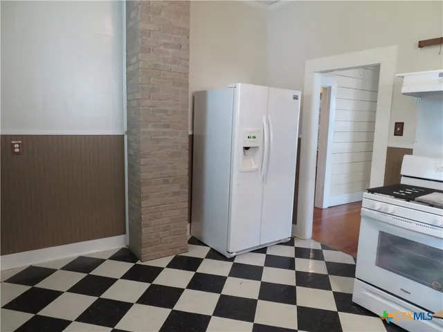 a kitchen with a checkered floor and a stove top oven
