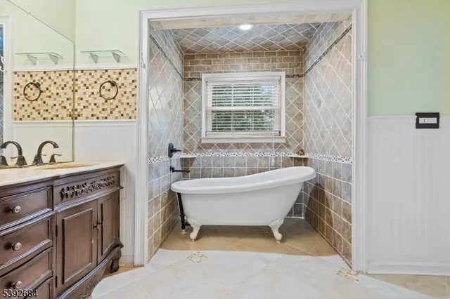 a bathroom with a tub sink and mirror