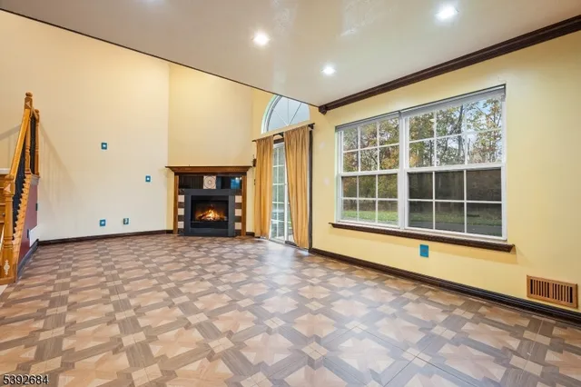a view of an empty room with a fireplace and a window