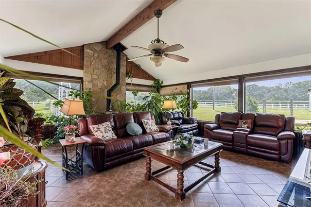 a living room with furniture and a floor to ceiling window