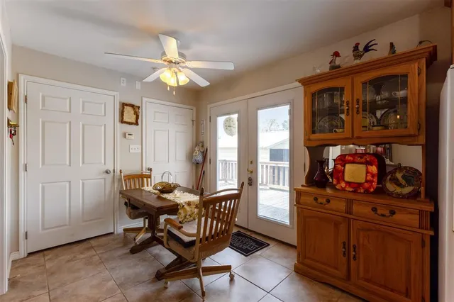 a bedroom with a bed a chair and potted plant on the dresser