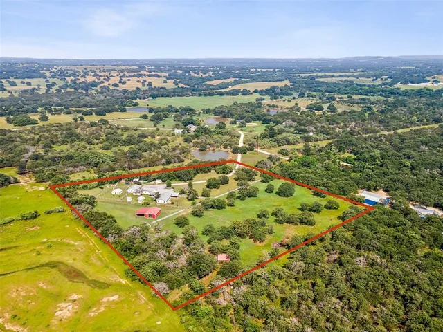 an aerial view of residential houses with outdoor space and trees