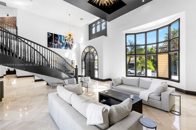 a kitchen with stainless steel appliances granite countertop a sink a stove a refrigerator cabinets and a dining table