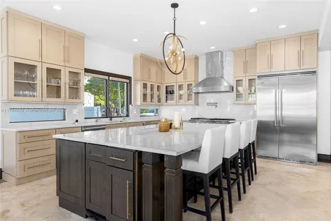 a large kitchen with granite countertop a stove a sink a dining table and chairs