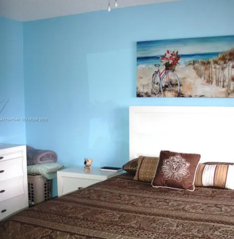 a bedroom with a bed and painting on the wall