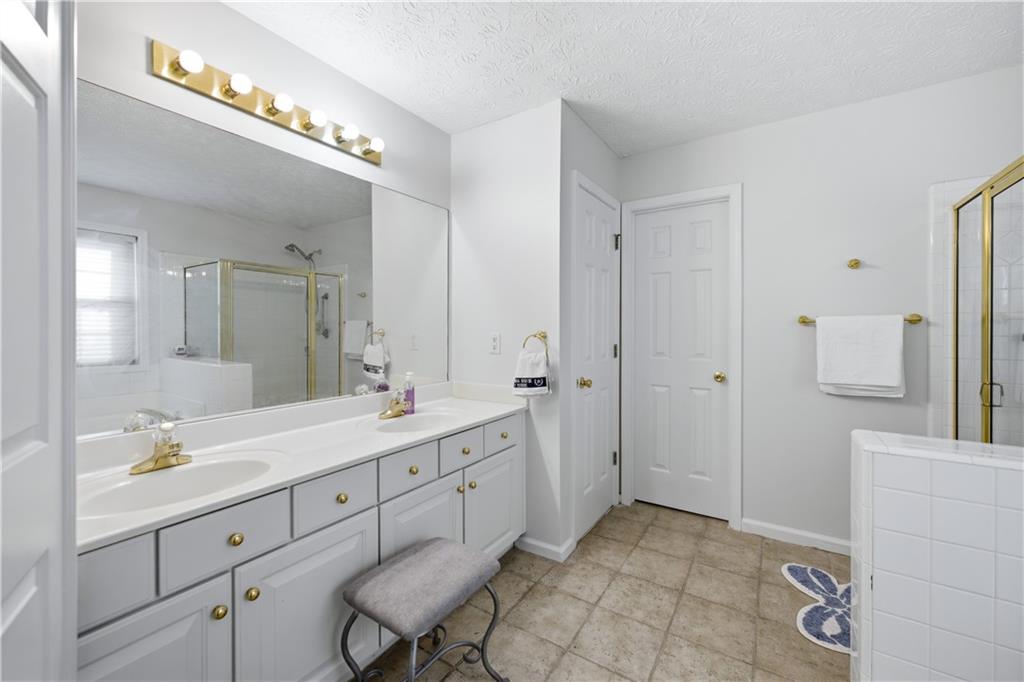 3324 Dunbar Lane Suwanee, GA 30024 - Photo 17 of 42 a spacious bathroom with a double vanity sink a mirror and a shower