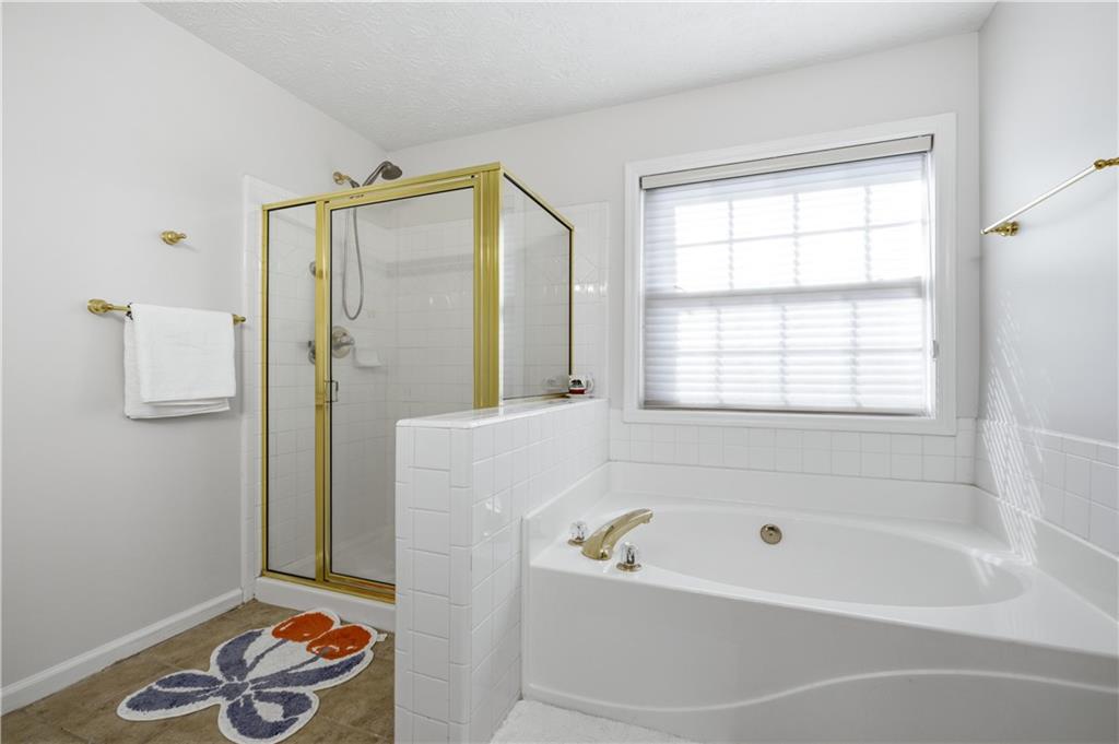 3324 Dunbar Lane Suwanee, GA 30024 - Photo 18 of 42 a bathroom with a bathtub and a shower