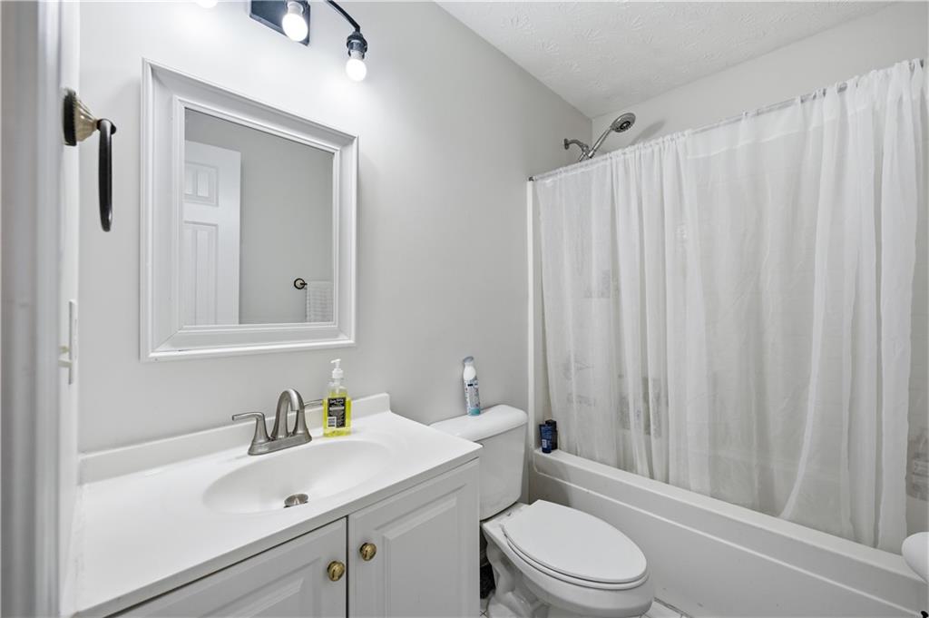 3324 Dunbar Lane Suwanee, GA 30024 - Photo 21 of 42 a bathroom with a sink a toilet and shower curtain