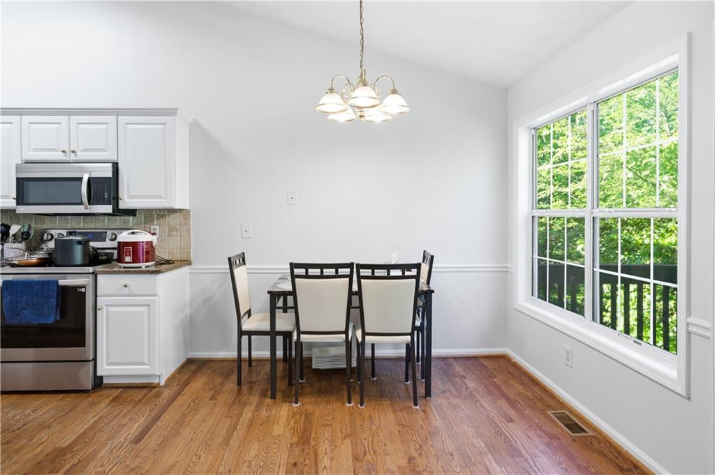 3324 Dunbar Lane Suwanee, GA 30024 - Photo 10 of 42 a dining room with furniture a window and wooden floor