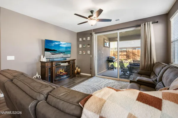 a living room with furniture a ceiling fan and a flat screen tv