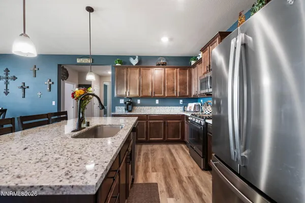 a kitchen with stainless steel appliances granite countertop a refrigerator a sink and a stove