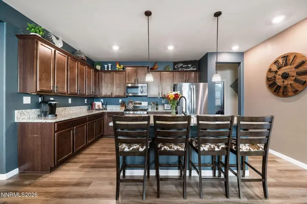 a kitchen with kitchen island a dining table chairs and white cabinets