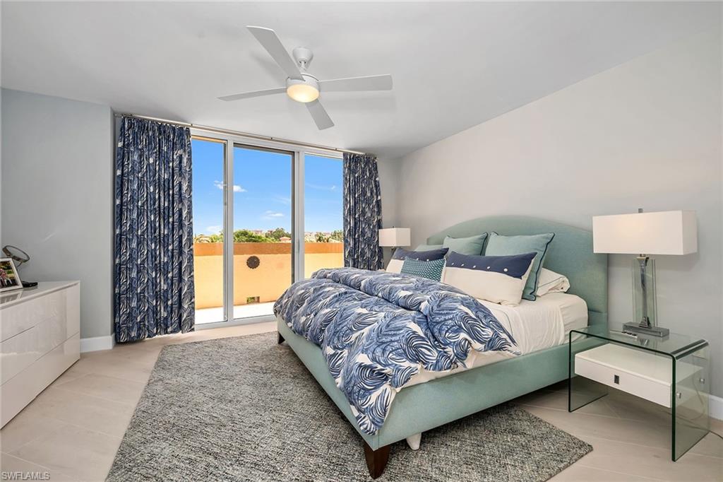 6597 Nicholas Boulevard, Unit 401 Naples, FL 34108 - Photo 12 of 28 a bedroom with a bed and a chandelier