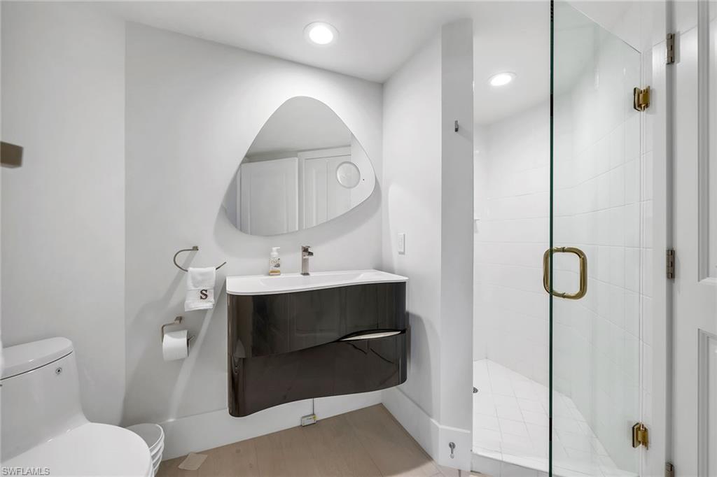 6597 Nicholas Boulevard, Unit 401 Naples, FL 34108 - Photo 13 of 28 a bathroom with a sink toilet and shower