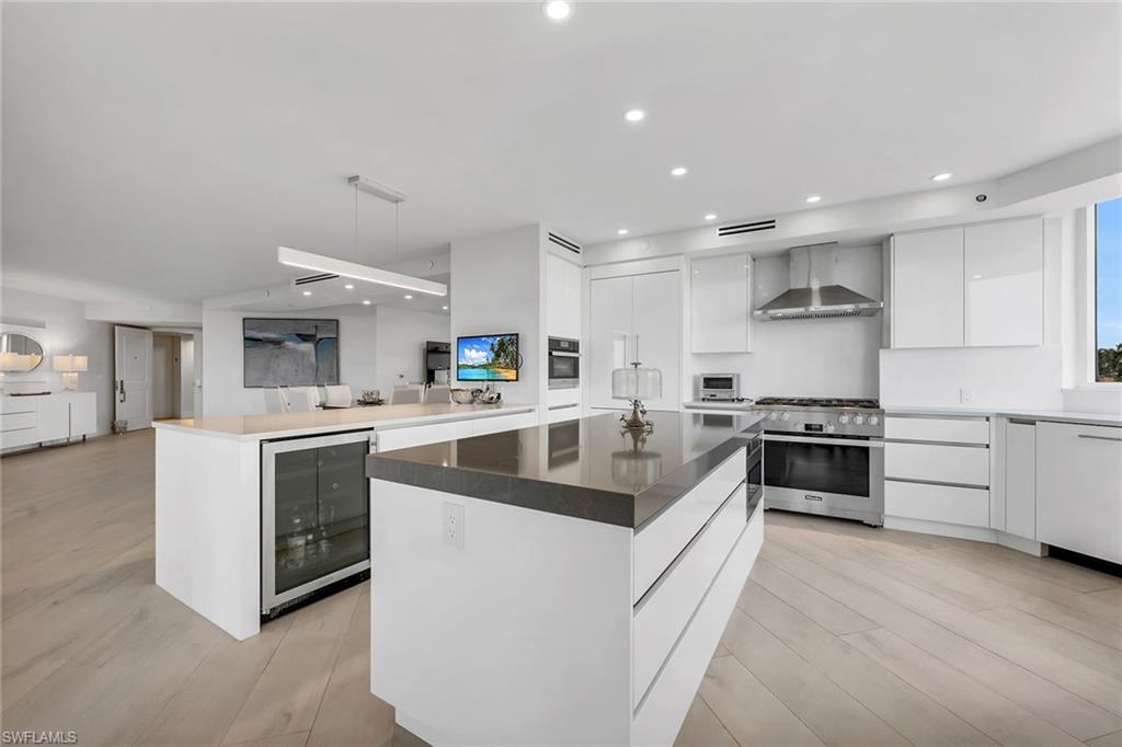 6597 Nicholas Boulevard, Unit 401 Naples, FL 34108 - Photo 5 of 28 a kitchen with stainless steel appliances granite countertop a sink and stove top oven