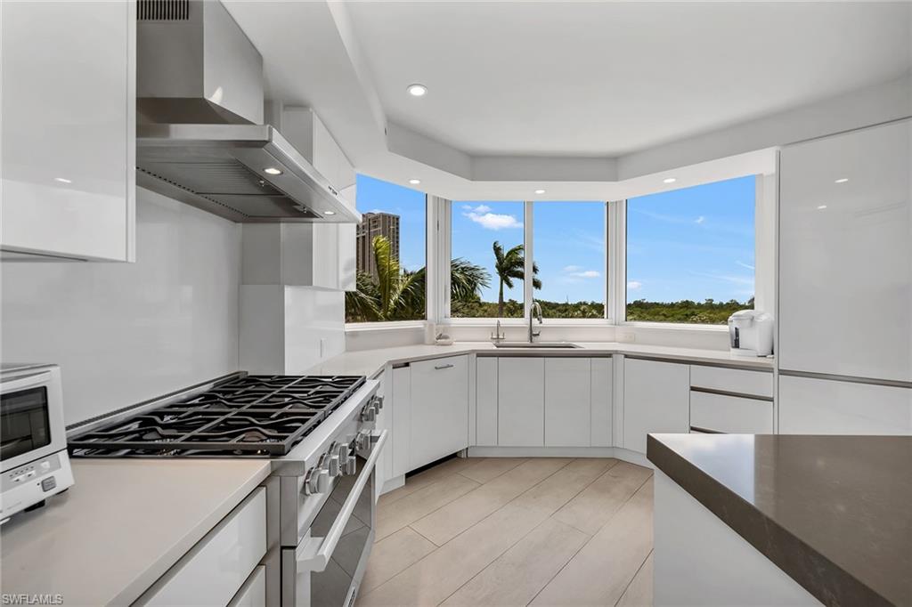 6597 Nicholas Boulevard, Unit 401 Naples, FL 34108 - Photo 6 of 28 a kitchen with stainless steel appliances a sink stove and cabinets