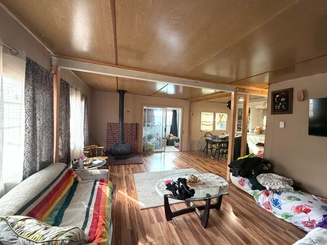 a kitchen with a refrigerator a stove a sink dishwasher and a dining table with wooden cabinet